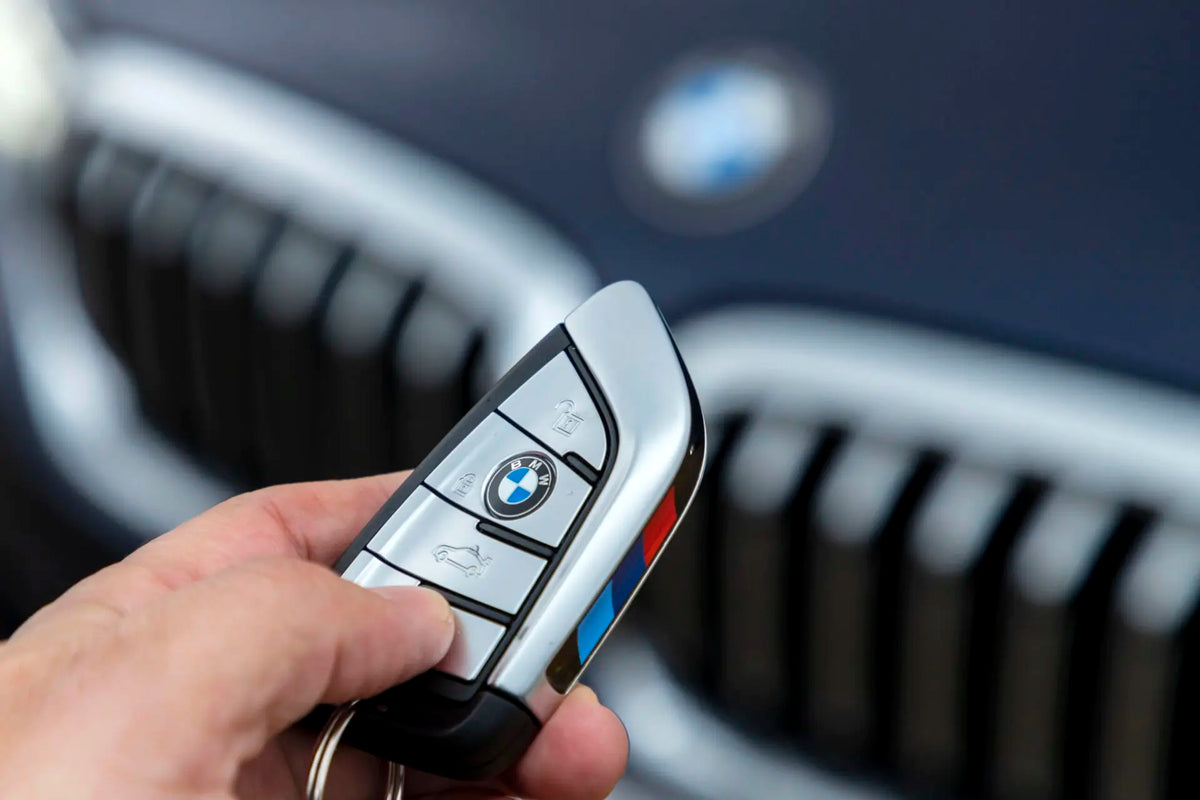 BMW key fob used to remotely start the engine, in front of a BMW kidney grille
